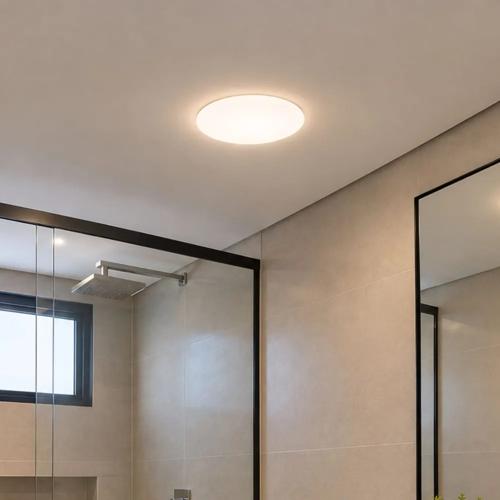 Painel LED Borda Infinita redondo no teto de um banheiro com box de vidro